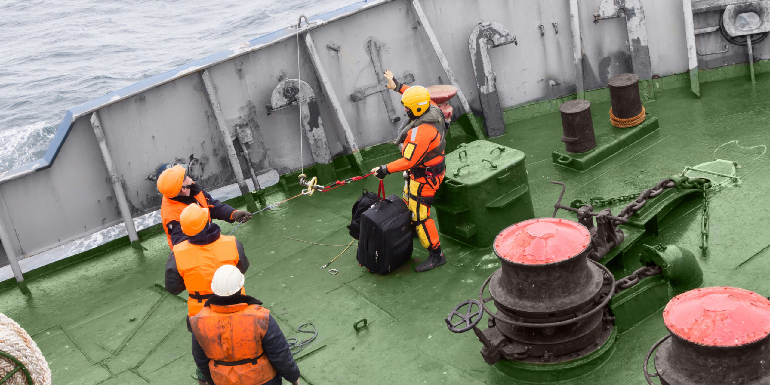 seamen carry out a rescue operation on the deck of a ship
